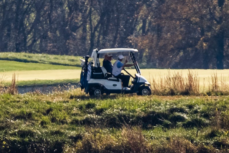 President Donald Trump waves to media across the Potomac River as he plays a round of golf at his private club, Trump National Golf Club, on November 8, 2020 in Sterling, Virginia. 