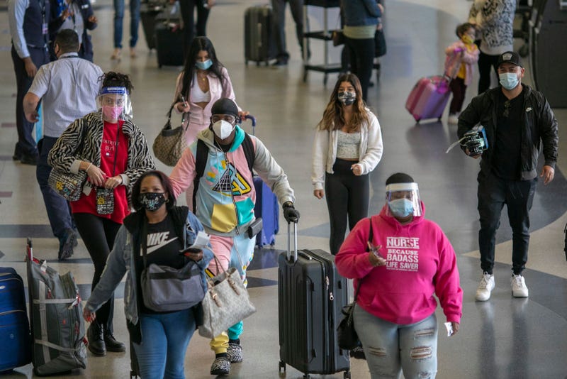 FILE - Holiday travelers pass through Los Angeles international Airport on Nov. 24, 2020 as the COVID-19 spike worsened and stay-at-home restrictions were set to be increased.