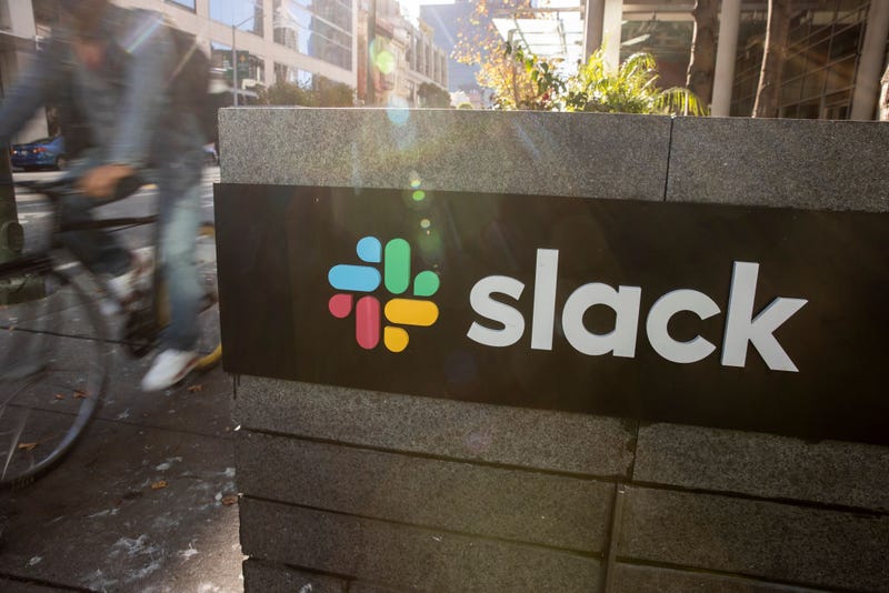 FILE - A bicyclist cycles past a Slack logo outside its headquarters on Dec. 1, 2020 in San Francisco, Calif.