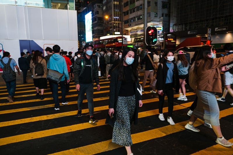 People wear protective masks and cross the street in Hong Kong December 9, 2020 in Hong Kong, China. 