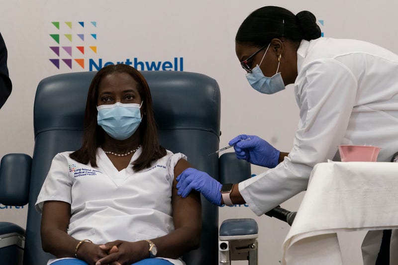 Sandra Lindsay(L), a nurse at Long Island Jewish Medical Center, is inoculated with the Covid-19 vaccine by Dr. Michelle Chester, at Long Island Jewish Medical Center, on December 14, 2020 in Queens.