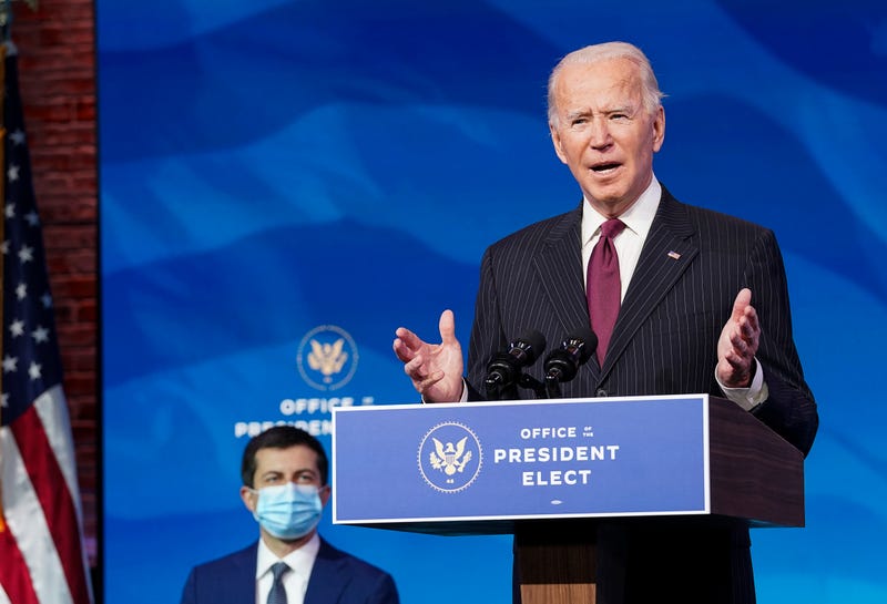 Former Democratic presidential candidate Pete Buttigieg (L) listens as U.S. President-elect Joe Biden announces his nomination during a news conference at Biden's transition headquarters on December 16, 2020 in Wilmington, Delaware.