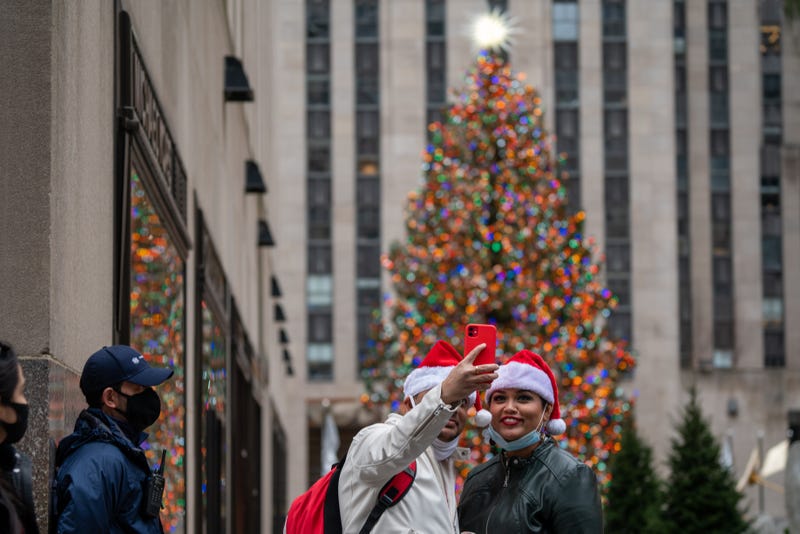 People pose for a selfie at the Rockefeller Christmas Tree on December 25, 2020 in New York City. People are celebrating Christmas during the pandemic as the city reports an increase of nearly 2,900 new cases and a 7 day positivity rate of 6.29%. 