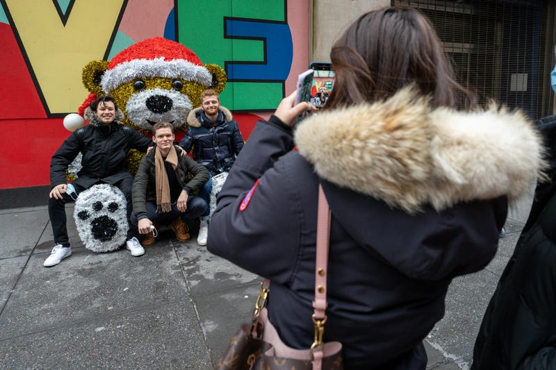 People pose for a photo at a sculpture of giant teddy bear with a Christmas hat on December 25, 2020 in New York City. People are celebrating Christmas during the pandemic as the city reports an increase of nearly 2,900 new cases and a 7 day positivity rate of 6.29%. 