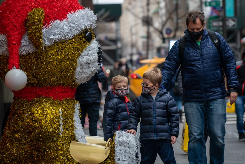 Children walk by a giant teddy bear with a Christmas hat on December 25, 2020 in New York City. People are celebrating Christmas during the pandemic as the city reports an increase of nearly 2,900 new cases and a 7 day positivity rate of 6.29%.