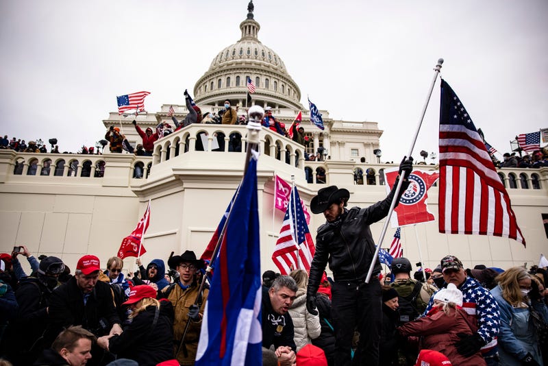 crowd outside the us capitol with american flags and trump banners