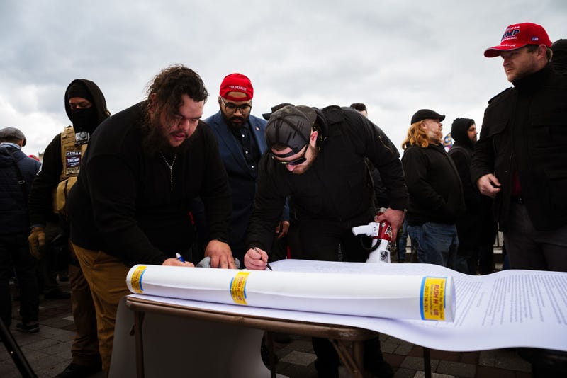 Members of the far-right group known as the Proud Boys sign a document on the grounds of the Capitol Building on January 6, 2021 in Washington, DC.