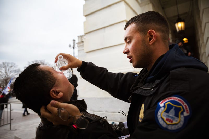 A U.S. Capitol Police officer tends to a Trump supporter suffering the effects of chemical agents used to disperse a mob that stormed the Capitol on Jan. 6, 2021, to stop Congress from certifying Joe Biden's Electoral College victory over Donald Trump.