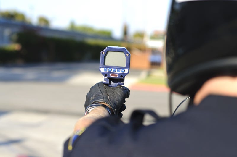 Stock photo of police officer using radar gun