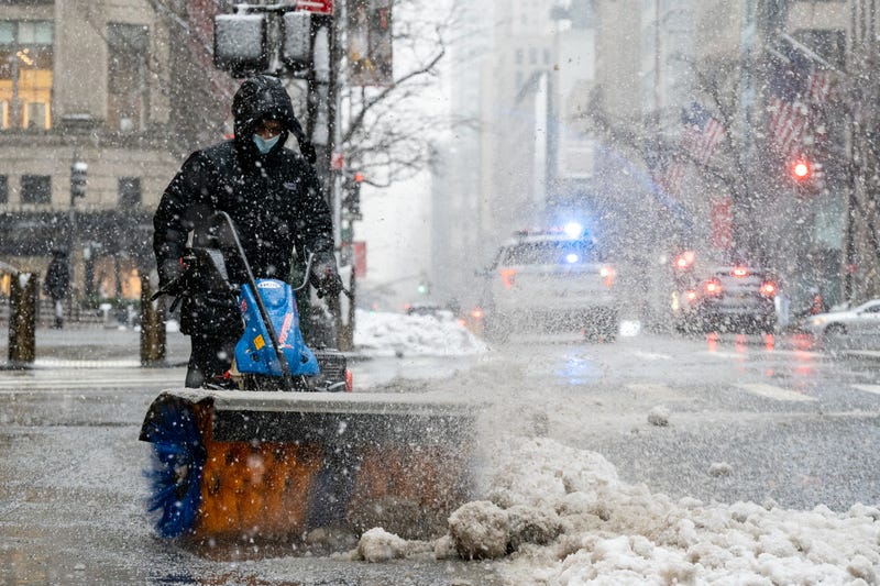 A maintenance worker clears snow of the side walk during a snow storm on February 7, 2021 in New York City