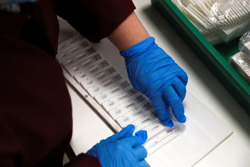 Employees assemble PCP coronavirus disease (COVID-19) test kits during a visit by Prime Minister Boris Johnson to SureScreen Diagnostics on February 7, 2021 in Derby, England