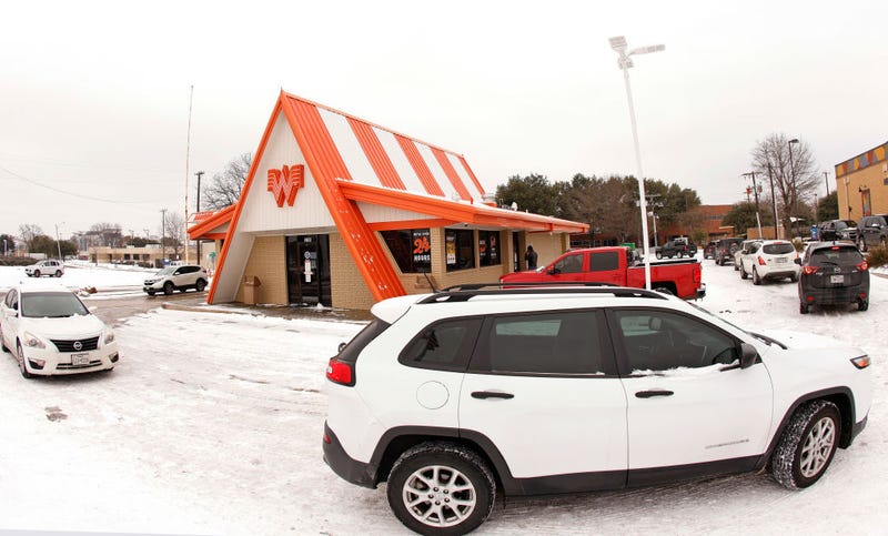 Cars wrap around a Whataburger franchise as they line up to order food after a snow storm on February 17, 2021 in Fort Worth,