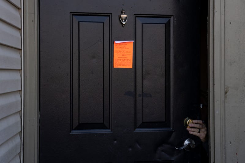 An eviction notice is posted as the lock is changed.