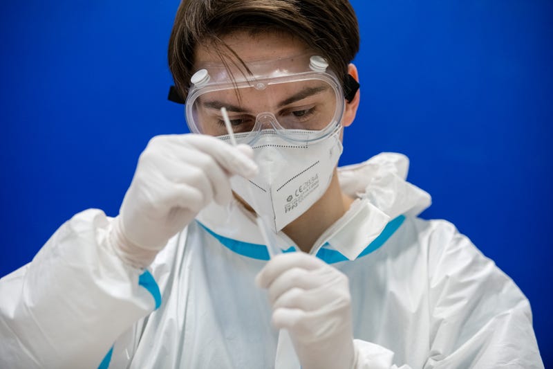 A worker with the Arbeiter Samariter Bund charity administers rapid antigen COVID-19 tests to high school students at the Ehrenfried Walther von Tschirnhaus Gymnasium high school on the second day after students returned to class during the coronavirus pandemic on March 16, 2021 in Dresden, Germany. Schools have been reopening across Germany, starting with the youngest pupils and more recently adding older students. Frequent COVID testing is part of the reopening concept, though not all regions have access to sufficient numbers of test kits. Health authorities warn however that the recent rise in COVID infections could be in part fuelled by the B117 variant spreading among children. (Photo by Jens Schlueter/Getty Images)