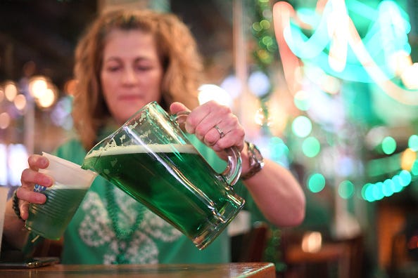 Woman pouring green beer for St. Patrick's Day. 
