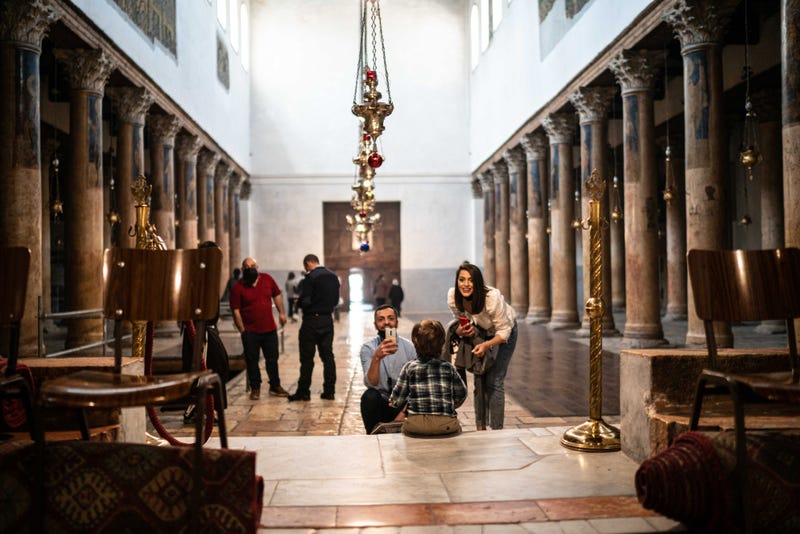 A Palestinian Christian couple take photos of their son as they celebrate Easter at the Church of the Nativity on April 4, 2021 in Bethlehem, West Bank.