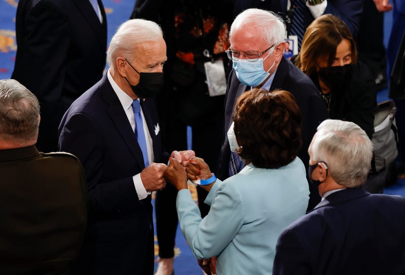 President Joe Biden stands next to Sen Bernie Sanders (I-Vt.)