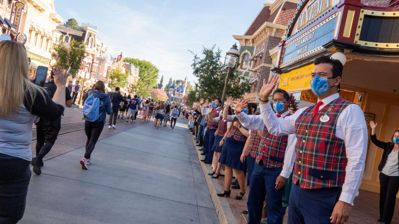 In this handout photo provided by Disneyland Resort, Guests as are waved to by workers as they take in the sights and sounds of Main Street U.S.A. at the Disneyland Resort on April 30, 2021 in Anaheim, California. Guests are being welcomed back as Disneyland Park, Disney California Adventure Park and Disney's Grand Californian Hotel & Spa are reopening. (Photo by Christian Thompson/Disneyland Resort via Getty Images)