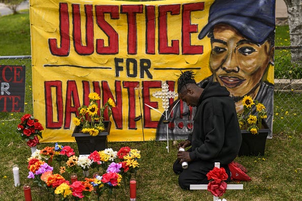 Antwon Davis lights candles at a memorial for Daunte Wright.