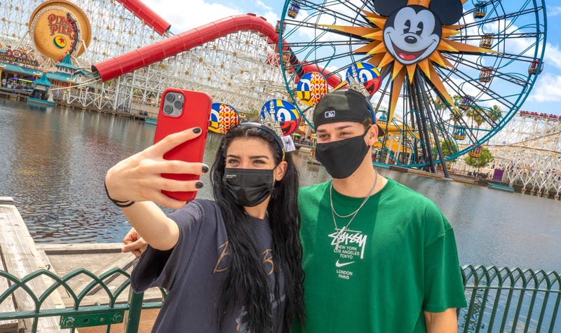Park visitors hold a phone at the Disneyland Resort in Anaheim, California.