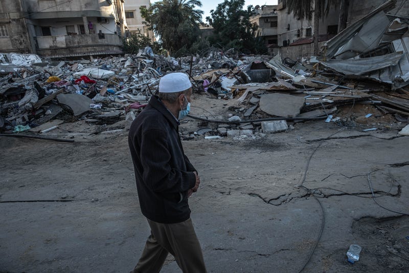 n elderly Palestinian man walks beside the rubble of a house, which was destroyed during an Israeli raid in the central Gaza Strip on May 18, 2021 in Gaza City, Gaza.