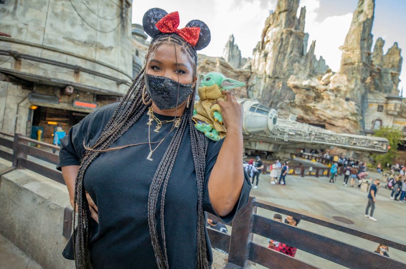 In this handout photo provided by Disneyland Resort, Grammy Award-winning recording artist Lizzo, poses with Baby Yoda in front of the Millennium Falcon in Star Wars: Galaxy's Edge at Disneyland Park on May 21, 2021 in Anaheim, California.