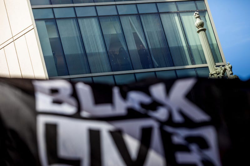 Police officers watch a Black Lives Matter protest in front of LAPD Headquarters on the first anniversary of George Floyd's murder, May 25, 2021 in Los Angeles, California.