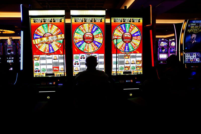A person sits at the slot machines on the casino floor.