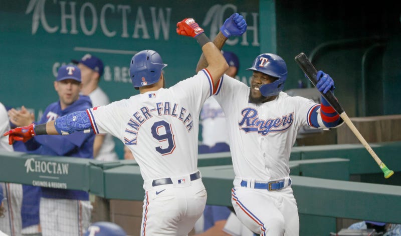 Isiah Kiner-Falefa #9 of the Texas Rangers celebrates with teammate Adolis Garcia #53 after hitting a two-run home run against the Minnesota Twins during the third inning at Globe Life Field on June 19, 2021 in Arlington, Texas.