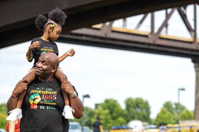 A young girl sits on a man's shoulders during the Louisville Juneteenth Festival at the Big Four Lawn on June 19, 2021 in Louisville, Kentucky.