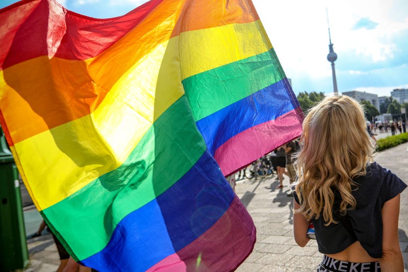 A participant holds the rainbow pride flag in the Queerschutz Now! (Queer Protection Now!) march through Karl-Marx-Allee street in commemoration and celebration of Christopher Street Day on June 26, 2021 in Berlin, Germany. A variety of gay pride marches and gatherings are taking place across the city today, each with its own political or thematic emphasis. The marches are taking place close to the 52nd anniversary of the 1969 riots following a police raid at The Stonewall Inn in New York City that ignited the gay rights movement. (Photo by Omer Messinger/Getty Images)