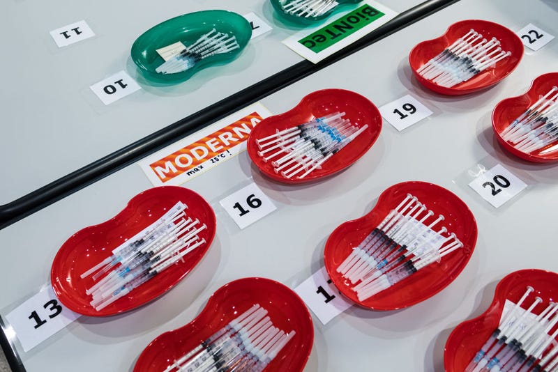 Syringes that contain the Pfizer/BioNTech vaccine (green) and the Moderna vaccine (red) against Covid-19.
