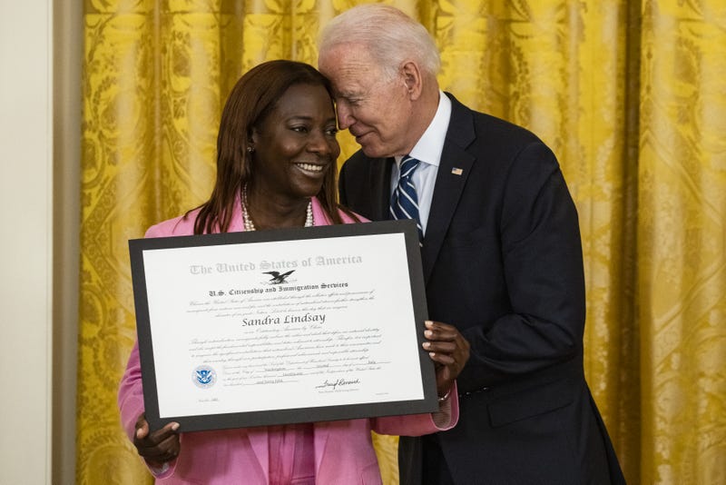 U.S. President Joe Biden presents Sandra Lindsay, a naturalized American Citizen and nurse who was first to receive the Covid-19 vaccine outside of trials, with the Outstanding American by Choice Award from the U.S. Citizen and Immigration Services during a naturalization ceremony in the East Room of the White House in Washington, D.C., U.S., on Friday, July 2, 2021. The ceremony is to welcome citizens to the United States ahead of Independence Day. Photographer: 