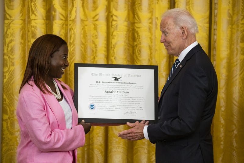 U.S. President Joe Biden presents Sandra Lindsay, a naturalized American Citizen and nurse who was first to receive the Covid-19 vaccine outside of trials, with the Outstanding American by Choice Award from the U.S. Citizen and Immigration Services during a naturalization ceremony in the East Room of the White House in Washington, D.C., U.S., on Friday, July 2, 2021. The ceremony is to welcome citizens to the United States ahead of Independence Day. 
