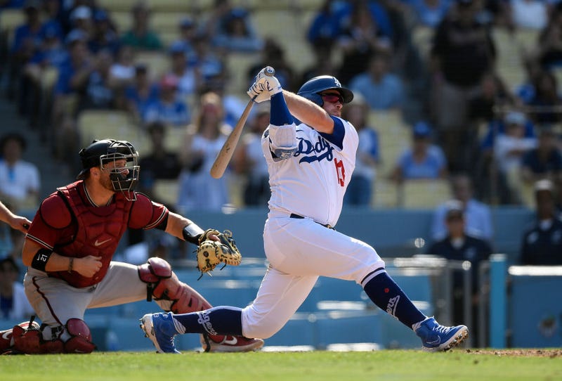 Max Muncy #13 of the Los Angeles Dodgers hits a walk-off, three-run home run during the ninth inning against the Arizona Diamondbacks at Dodger Stadium on July 11, 2021 in Los Angeles, California.