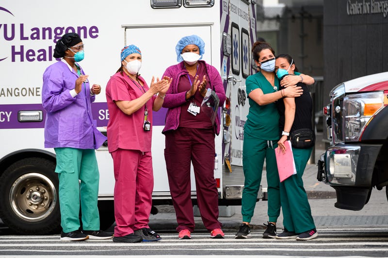 Medical workers stand outside NYU Langone Health hospital as people applaud to show their gratitude to medical staff and essential workers during the coronavirus pandemic on May 29, 2020 in New York City.