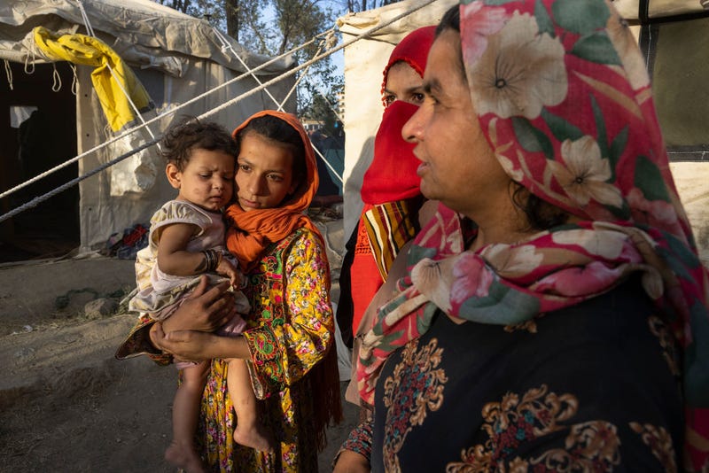 alida ,11, from Tahar, who lost her father, killed by the Taliban holds her cousin Shafika, 8 months, along side family as displaced Afghans arrive at a makeshift camp from the northern provinces desperately leaving their homes behind on August 10, 2021 in Kabul, Afghanistan.