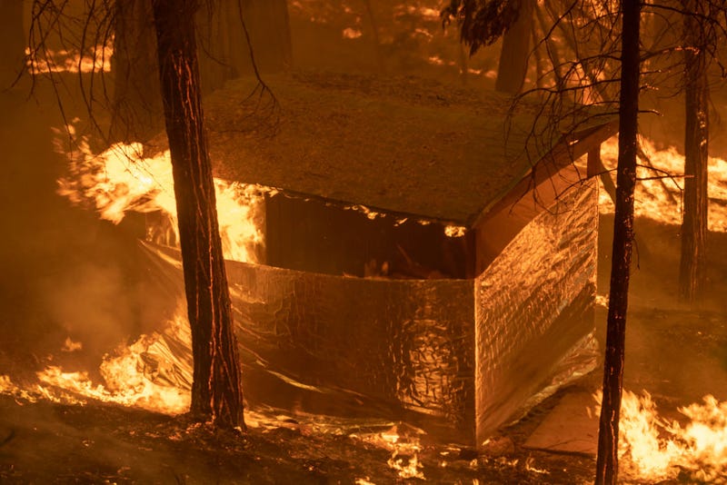 A structure that firefighters had covered with structure wrap in hopes that it might survive catches fire in Slick Rock Canyon as the French Fire continues to spread.