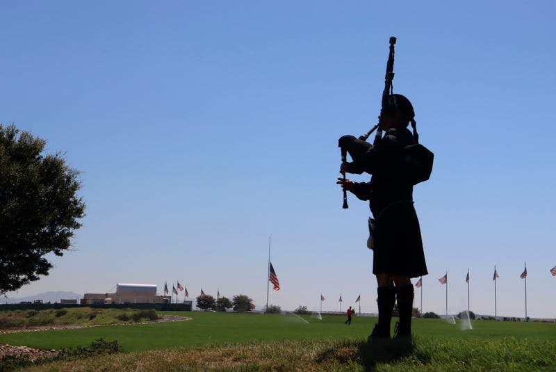 A bagpiper plays during a ceremony for fallen Navy Seals as a flag flies at half staff at Miramar National Cemetery on August 27, 2021 in San Diego, California. Over 170 civilians were killed, including 13 U.S. Servicemen during an ISIS led terrorist attack outside of the Kabul Airport