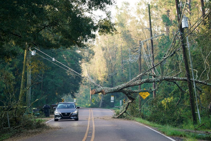 A motorist passes under a storm damaged utility line on September 1, 2021 in Hammond, Louisiana. Tropical Storm Ida made landfall as a Category 4 hurricane Sunday in Louisiana and brought flooding, wind damage and power outages along the Gulf Coast. (Photo by Sean Rayford/Getty Images)