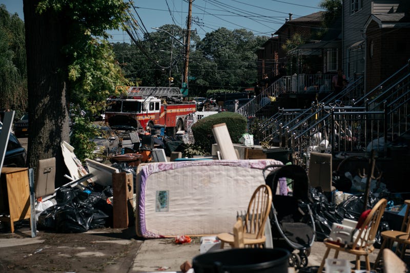 Residents sort through damaged and destroyed items after a night of heavy rain and wind caused many homes to flood on September 2, 2021 in the Flushing neighborhood of the Queens