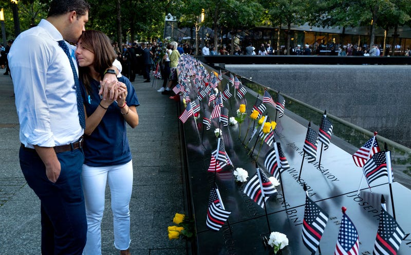 Katie Mascali is comforted by her fiance Andre Jabban as they stand near the name of her father Joseph Mascali during a ceremony at the National September 11 Memorial & Museum commemorating the 20th anniversary of the September 11th terrorist attacks on the World Trade Center on September 11, 2021 in New York City.
