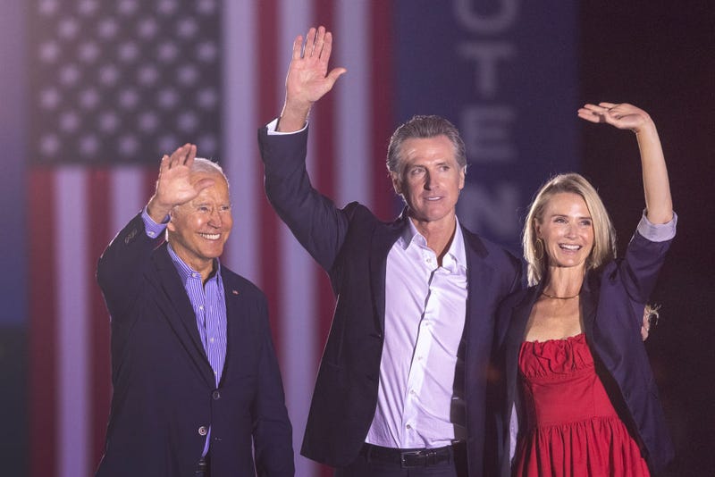 U.S. President Joe Biden, California Gov. Gavin Newsom and Jennifer Lynn Siebel Newsom wave to the crowd as they campaign to keep the governor in office. Newsom thanked Californians Tuesday night after incomplete returns showed he would handily defeat the recall attempt. 