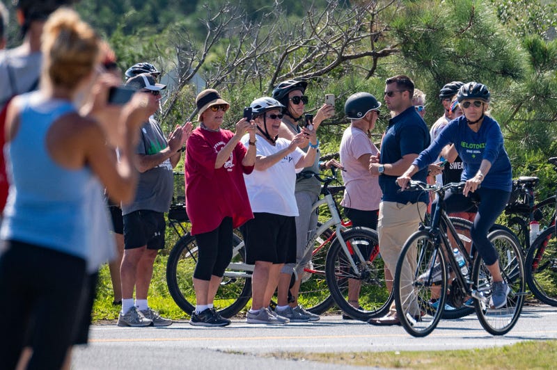 US President Joe Biden (C) rides his bike through Cape Henlopen State Park in Rehoboth Beach, Delaware, on September 19, 2021. 