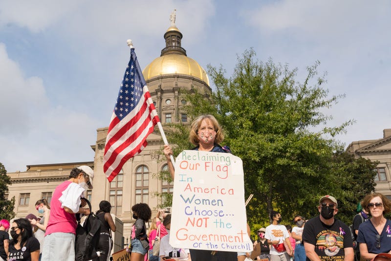 Renee Bates holds a flag and a sign as demonstrators rally in support of women's reproductive rights at the Georgia State Capitol on October 2, 2021 in Atlanta, Georgia. The Women's March and other groups organized marches across the country to protest the new abortion law in Texas.