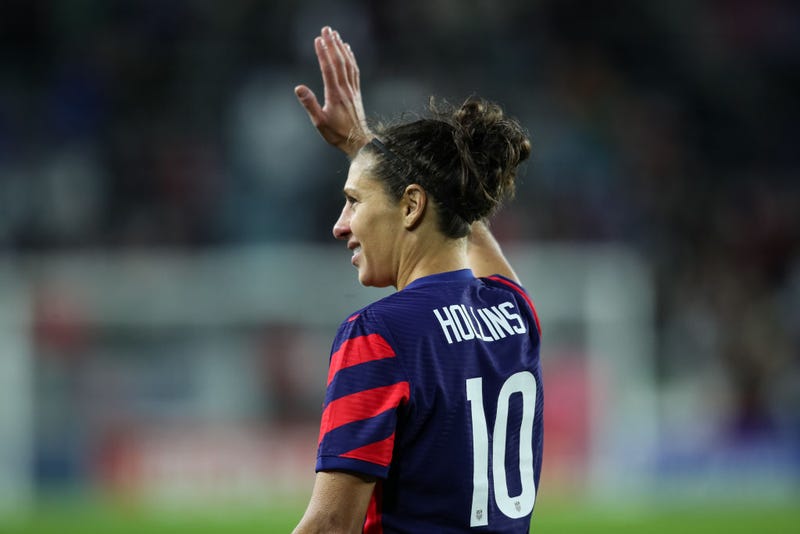 Carli Lloyd, wearing married name Hollins on back of jersey, waves to fans
