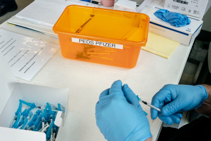 A firefighter prepares pediatric doses of the Pfizer-BioNtech Covid-19 vaccine on November 3, 2021 in Shoreline, Washington.