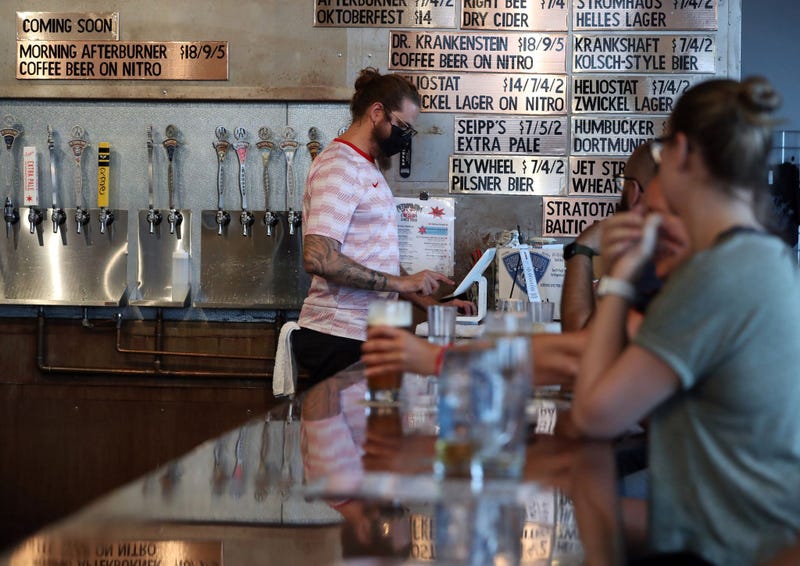 Bartender Marty Tomszak, left, pours a beer at Metropolitan Brewing taproom, on Aug. 10, 2021.