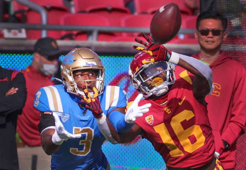 USC wide receiver That Washington, right, UCLA defensive back Cameron Johnson deflect a pass in the first quarter at Los Angeles Memorial Coliseum in Los Angeles on Saturday, Nov. 20, 2021.