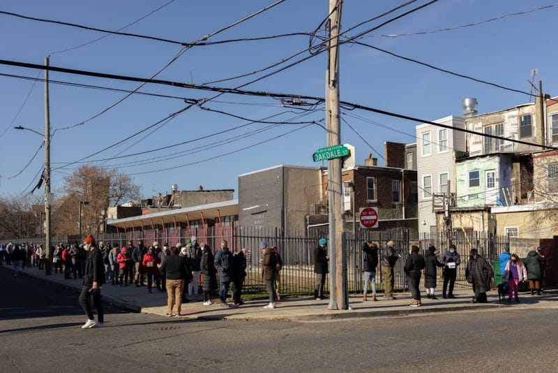 Residents wait in line to receive free rapid at-home COVID-19 test kits at a vaccine clinic in Philadelphia, Dec. 20, 2021.
